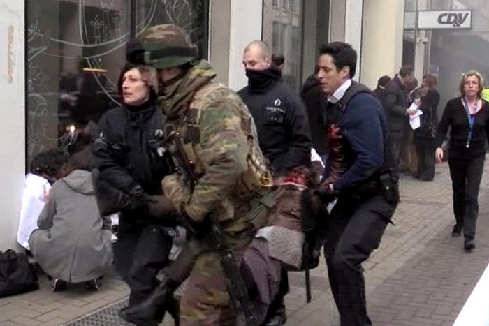 epa05225187 A TV grab image shows Belgian policemen and a soldier carrying an injured person after an explosion at the Maelbeek Metro station in Brussels, Belgium, 22 March 2016. Brussels has shut down its all of its metro services after blasts occurred in Schuman and Maelbeek metro stations near European Union buildings, local news reports. At least one person was killed and many injured, according to a local witness, although the number of deaths and injuries has not been confirmed by official sources. The blast comes just hours after dozens of people were killed or injured in a double explosion in the departure hall of Zaventem Airport in Brussels.  EPA/STR BEST QUALITY AVAILABLE