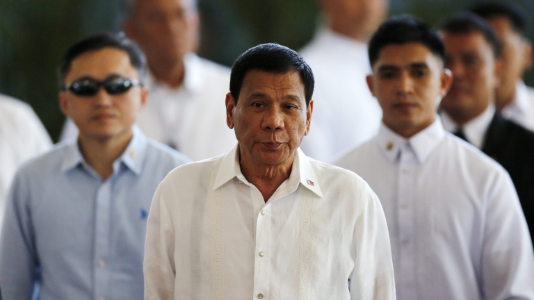 epa05601569 Filipino President Rodrigo Duterte (C) is escorted during a departure ceremony at Manila's international airport, Philippines, 25 October 2016. Duterte leaves for Japan to meet Prime Minister Shinzo Abe. The two are expected to agree on expanding bilateral ties in areas of maritime security and defense cooperation, according to news reports.  EPA/FRANCIS R. MALASIG