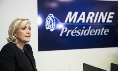epa05633472 French far right party leader Marine Le Pen sits next to her campaign sign as she launches her campaign for the French presidential elections of 2017 in Paris, France, 16 November 2016.  EPA/ETIENNE LAURENT