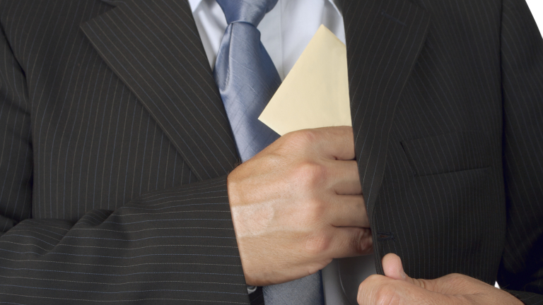 Businessman putting an envelope in his jacket pocket - concept of bribe