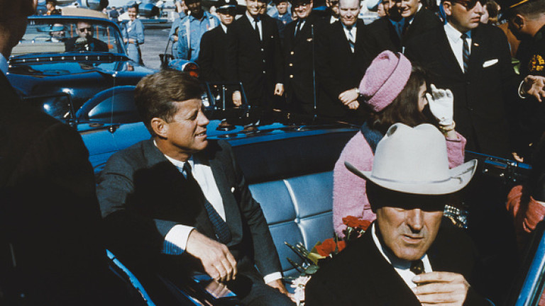 President of the United States, John F Kennedy (1917-1963) pictured with his wife Jacqueline Kennedy (1929-1994) seated in the rear seat of an open top limousine forming part of a presidential motorcade at Dallas Love Field airport on 22nd November 1963. Governor John Connally sits in the seat in front of the President. President Kennedy would be assassinated later the same day. (Photo by Rolls Press/Popperfoto/Getty Images)
