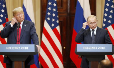 epaselect epa06893404 US President Donald J. Trump (L) and Russian President Vladimir Putin (R) adjust their earpiece plugs during a joint press conference following their summit talks at the Presidential Palace in Helsinki, Finland, 16 July 2018.  EPA/ANATOLY MALTSEV