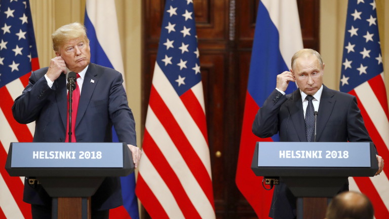 epaselect epa06893404 US President Donald J. Trump (L) and Russian President Vladimir Putin (R) adjust their earpiece plugs during a joint press conference following their summit talks at the Presidential Palace in Helsinki, Finland, 16 July 2018.  EPA/ANATOLY MALTSEV