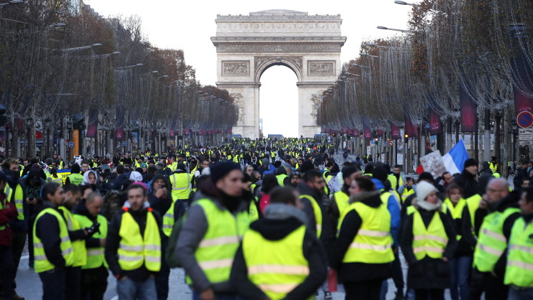 epa07216113 Yellow Vests protesters walk down the Champs Elysees avenue to Place de la Concorde during a demonstration in Paris, France, 08 December 2018. Police in Paris is preparing for another weekend of protests of the so-called 'gilets jaunes' (yellow vests) protest movement. Recent demonstrations of the movement, which reportedly has no political affiliation, had turned violent and caused authorities to close some landmark sites in Paris this weekend.  Seen in background is the landmark Arc de Triomphe.  EPA/IAN LANGSDON