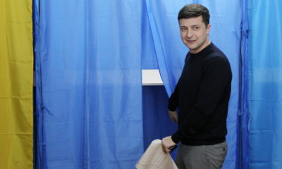 epaselect epa07475613 Ukrainian showman, comedian, and presidential candidate Volodymyr Zelenskiy stands next to a voting booth as he prepares to cast his ballot at a polling station in Kiev, Ukraine, 31 March 2019. Ukraine votes for one of 39 candidates on 31 March to decide on the country's new president.  EPA/STEPAN FRANKO