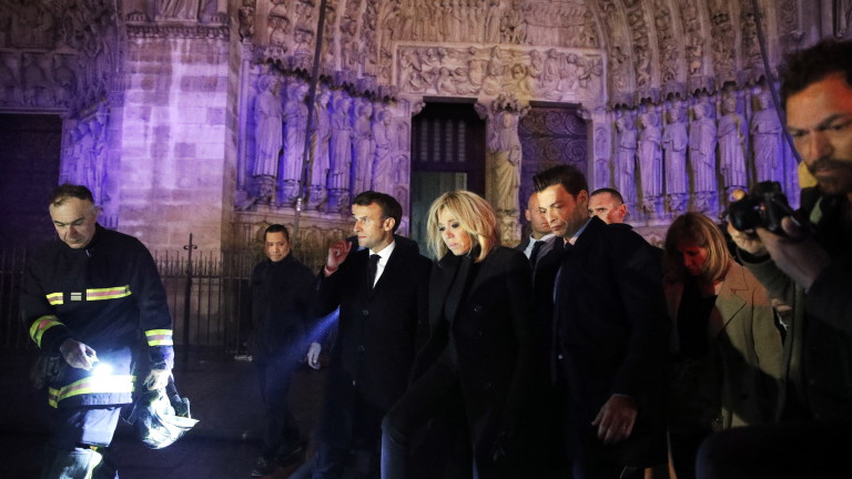 epa07509136 French President Emmanuel Macron (C) and his wife Brigitte Macron (R) pay a visit to firemen fighting against a fire burning the roof of the Notre-Dame cathedral in Paris, France, 15 April 2019. A fire started in the late afternoon in one of the most visited monuments of the French capital.  EPA/YOAN VALAT