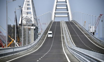 epa06737904 A car drives on the Krymsky (Crimean) Bridge over the Kerch Strait 15 May 2018, prior to its opening ceremony. The 19-kilometers-long road-and-rail bridge connects the Crimean peninsula,  annexed by Russia from Ukraine in March 2014, with the Taman Peninsula of the Russian mainland. Public transport and automobiles traffic on Crimean Bridge will be launched in early hours of 16 May 2018.  EPA/ALEXANDER NEMENOV / POOL